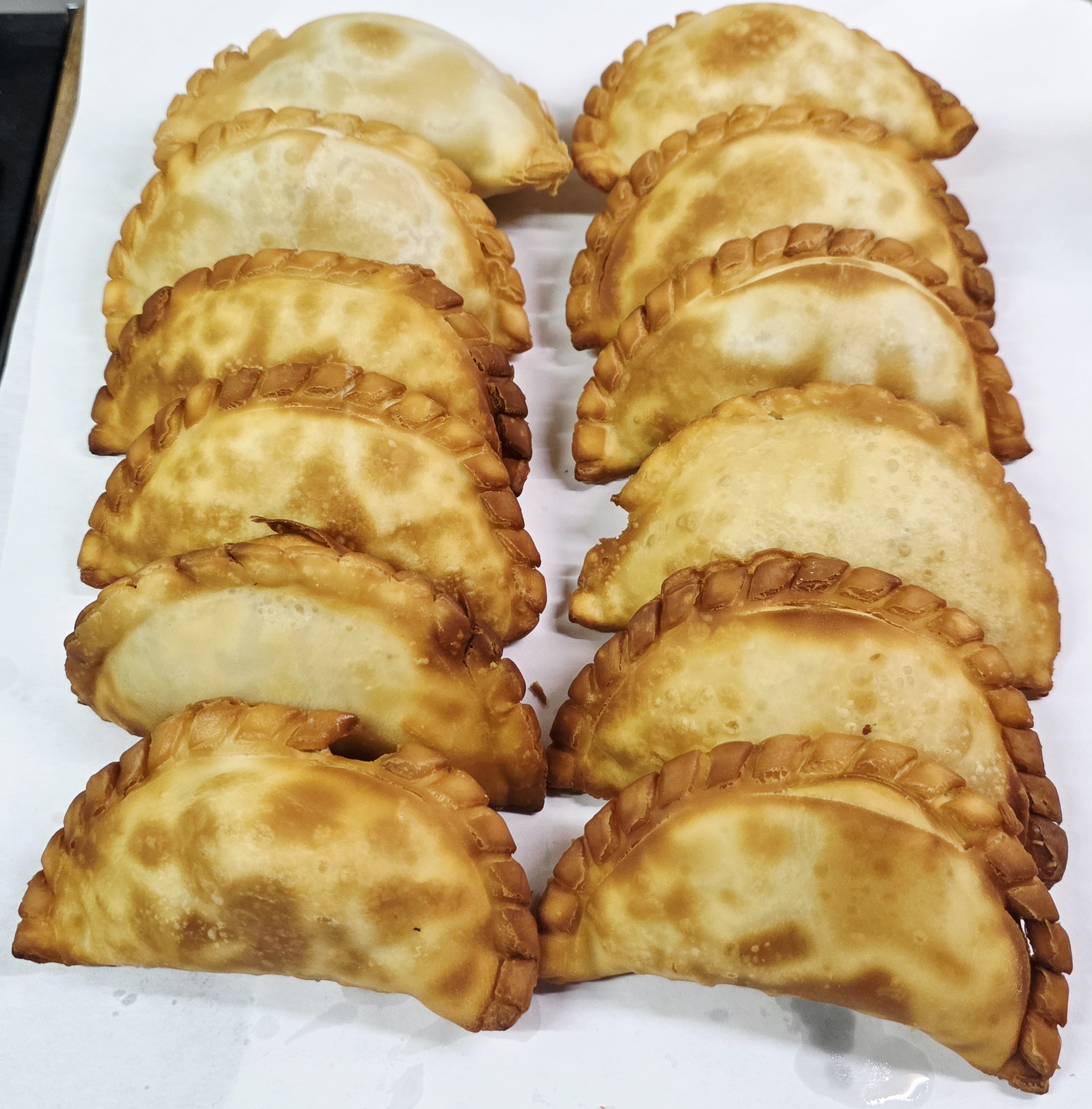 Photoreal photograph of the finished dish Beef empanadas (empanadas), the actual plate from Argentina, handmade ceramic, natural window light, shallow depth of field, no text, no logo, no people, Natural window light, ivory linen, handmade ceramic, shallow depth of field, no text, no logo, no watermark, fine-dining magazine photograph. Beef empanadas