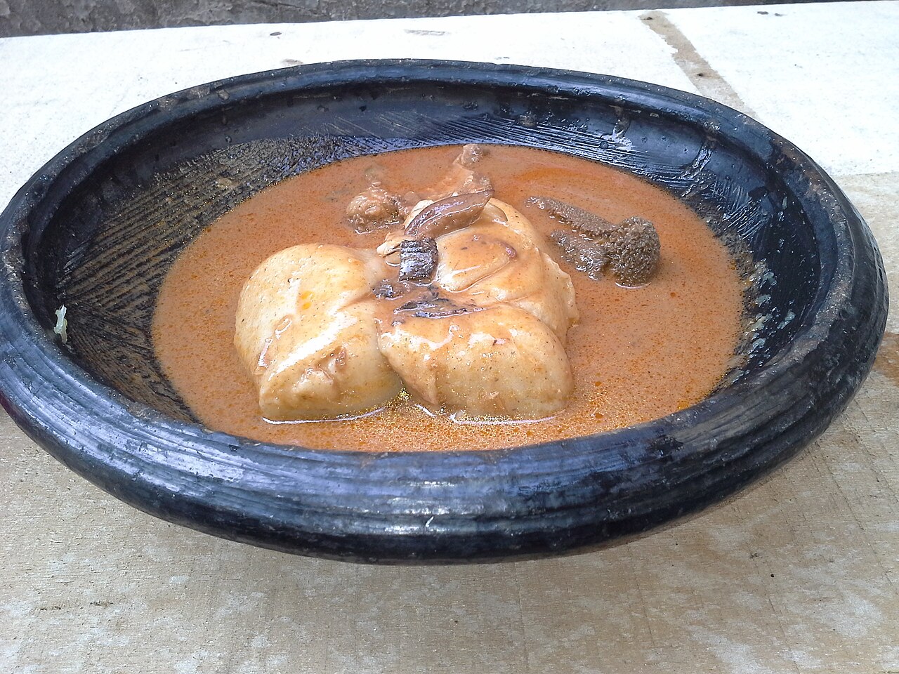 Photoreal photograph of the finished dish Groundnut soup (Nkatenkwan), the actual plate from Ghana, handmade ceramic, natural window light, shallow depth of field, no text, no logo, no people, Natural window light, ivory linen, handmade ceramic, shallow depth of field, no text, no logo, no watermark, fine-dining magazine photograph. Groundnut soup