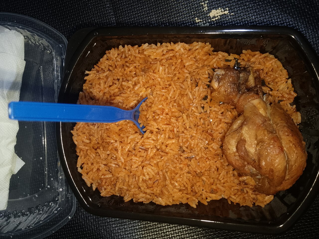 Photoreal photograph of the finished dish Ghanaian jollof (Jollof), the actual plate from Ghana, handmade ceramic, natural window light, shallow depth of field, no text, no logo, no people, Natural window light, ivory linen, handmade ceramic, shallow depth of field, no text, no logo, no watermark, fine-dining magazine photograph. Ghanaian jollof