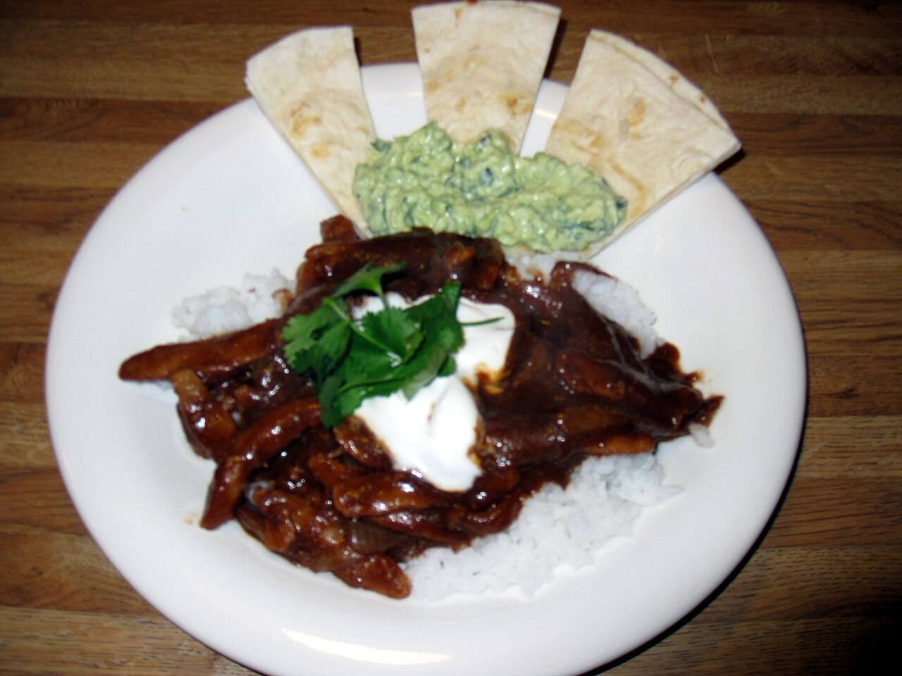 Photoreal photograph of the finished dish Chicken mole (mole poblano), the actual plate from Mexico, handmade ceramic, natural window light, shallow depth of field, no text, no logo, no people, Natural window light, ivory linen, handmade ceramic, shallow depth of field, no text, no logo, no watermark, fine-dining magazine photograph. Chicken mole