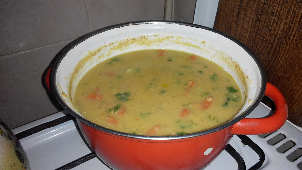Photoreal photograph of the finished dish Lentil soup (شوربة عدس), the actual plate from Sudan, handmade ceramic, natural window light, shallow depth of field, no text, no logo, no people, Natural window light, ivory linen, handmade ceramic, shallow depth of field, no text, no logo, no watermark, fine-dining magazine photograph. Lentil soup